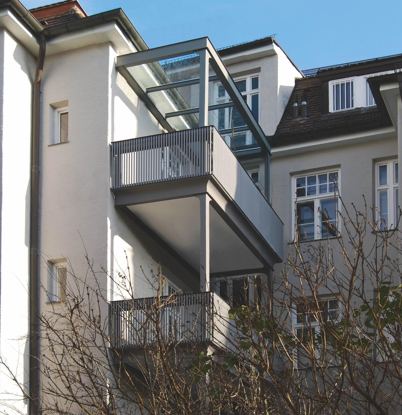 Großer Anlehbalkon mit rundem Sockelblech und Balkondach in Klarglas